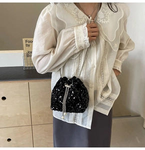 Détail du sac seau noir à paillettes avec chaîne argentée et perles décoratives