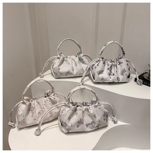 Chic butterfly print pleated cloud bags in four colors on a modern display stand