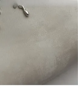 Macro detail of lightweight off-white textured fabric with fluid silver metal accents