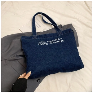 Dettaglio della borsa tote in denim blu con ricamo bianco Less Mondays More Sundays