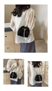 Close-up of black sequined bucket bag with pearl drawstring and silver chain strap