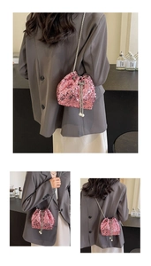 Detailed close-up of pink sequin bucket bag featuring silver chain and pearl tassels