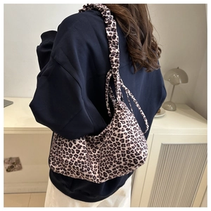 Detail of leopard print shoulder bag with elegant pleated ruffled strap and soft texture