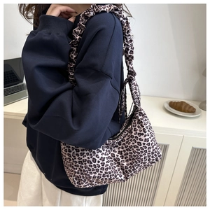 Detailed close-up of leopard print canvas tote bag with stylish ruffled shoulder strap