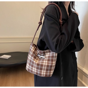 Detail of checkered shoulder bag with dachshund embroidery and knotted leather strap