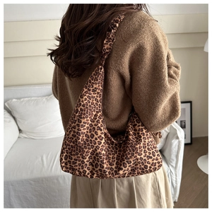 Detail of leopard print hobo bag featuring a ruffled strap and large canvas structure