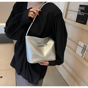 Détail d'un sac à bandoulière argenté métallisé avec petit nœud et fine lanière