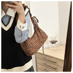 Close-up of leopard print hobo bag with pleated shoulder strap in a mirror selfie