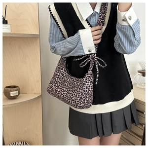 Detail of leopard print crossbody bag with knotted strap and crescent moon shape