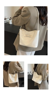 Détail du sac sous le bras en cuir blanc crème avec un nœud décoratif et fini lisse