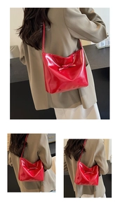 Détail du sac bandoulière en cuir verni rouge avec finition brillante et nœud décoratif
