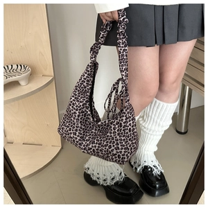 Detail shot of leopard print hobo bag featuring a unique scrunchie style shoulder strap