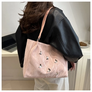 Pale pink tote bag with silver butterfly charms and pleated texture on model