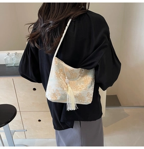 Detail of elegant Chinese style bucket bag with traditional landscape embroidery and tassel