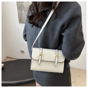Detailed side view of a white rectangular crossbody bag on a model showing fine edge oiling