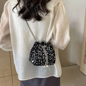 Fashionable black sequin bucket bag with silver chain strap and pearl drawstring details