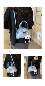 Detail of light blue crossbody bag featuring metallic bow and plush cloud charm