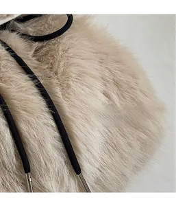 Detail of plush beige faux fur material with soft texture and black woven drawstrings