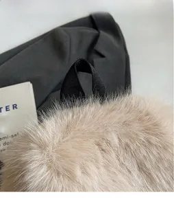 Detail of soft cream faux fur backpack with durable black nylon carry handle and fluffy texture