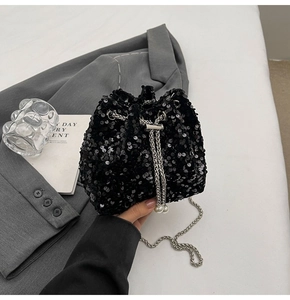 Dettaglio della borsa a secchiello con paillettes nere, catena e ciondoli di perle