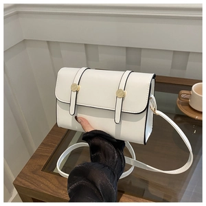 Detail of white minimalist crossbody bag with gold buckles and black edge stitching