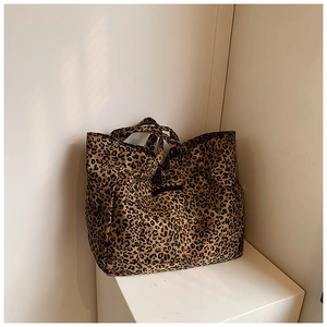 Detailed macro view of large leopard print tote bag fabric and black decorative patch
