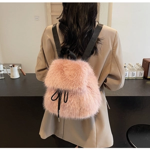 Detail of pink faux fur mini backpack with soft texture and black ribbon bow detail