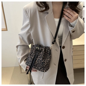 Detail of trendy leopard print bucket bag with drawstring closure on beige blazer outfit