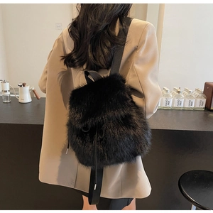 Rear view of a black faux fur backpack with adjustable straps and drawstring closure