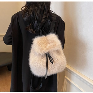 Detail of plush beige faux fur backpack with drawstring closure and black straps