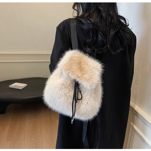 Detail of plush beige faux fur backpack with black drawstring and slim straps for winter
