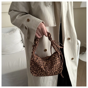 Detail of leopard print handbag with a stylish ruched scrunchie handle and bow detail
