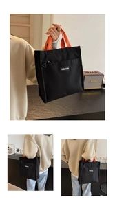 Vue détaillée du sac cabas en toile noire avec anses oranges et poche zippée avant