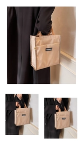 Détail du sac cabas en nylon beige avec poche zippée et poignées marron robustes