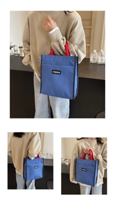 Détail du sac cabas en nylon bleu marine avec poignées rouges et poche zippée