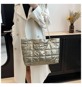 Detail of champagne gold quilted tote bag with chain strap and deer pendant charm