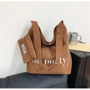 Detailansicht eines braunen Cord-Shopper-Sets mit gestickten Buchstaben und Beutel