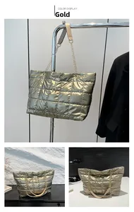 Close-up of golden quilted tote bag with metallic sheen, deer charm, and chain strap