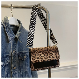 Detail of leopard print crossbody bag with stylish patterned wide shoulder strap