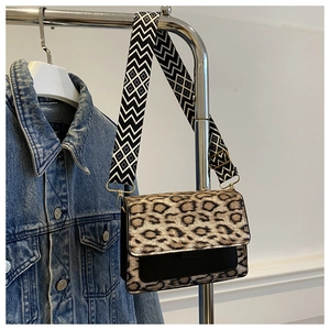 Detail of leopard print crossbody bag with stylish geometric patterned shoulder strap