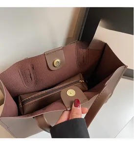 Interior detail of large brown tote bag with removable zipper pouch and magnetic closure