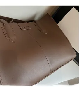 Detailed macro view of high-quality brown leather tote bag with embossed fashion text