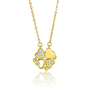 Macro detail of gold-tone four-leaf clover necklace with sparkling zircon heart petals
