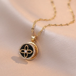 Elegant gold necklace with rotating black four-leaf clover pendant and zircon accents