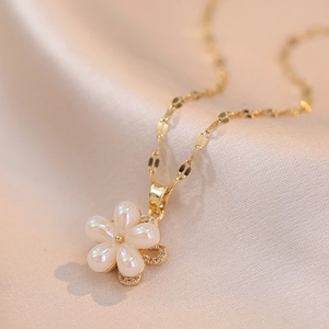 Iridescent flower pendant necklace with gold chain on elegant champagne silk fabric