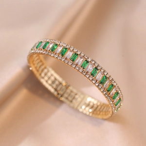 Bracciale dorato con pietre rettangolari verde smeraldo e pavé di zirconi scintillanti