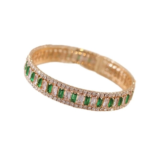 Bracciale aperto dorato con pietre verdi e bianche taglio smeraldo e zirconi lucidi
