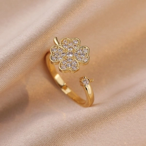 Bague trèfle dorée ajustable ornée de zircons cubiques sur fond de soie élégant
