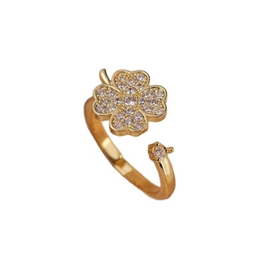 Bague trèfle dorée ajustable ornée de zircons brillants sur un fond blanc épuré