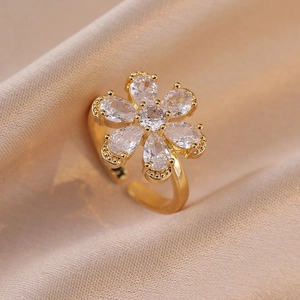 Elegant adjustable petal ring with pear-cut zircon stones on champagne silk fabric